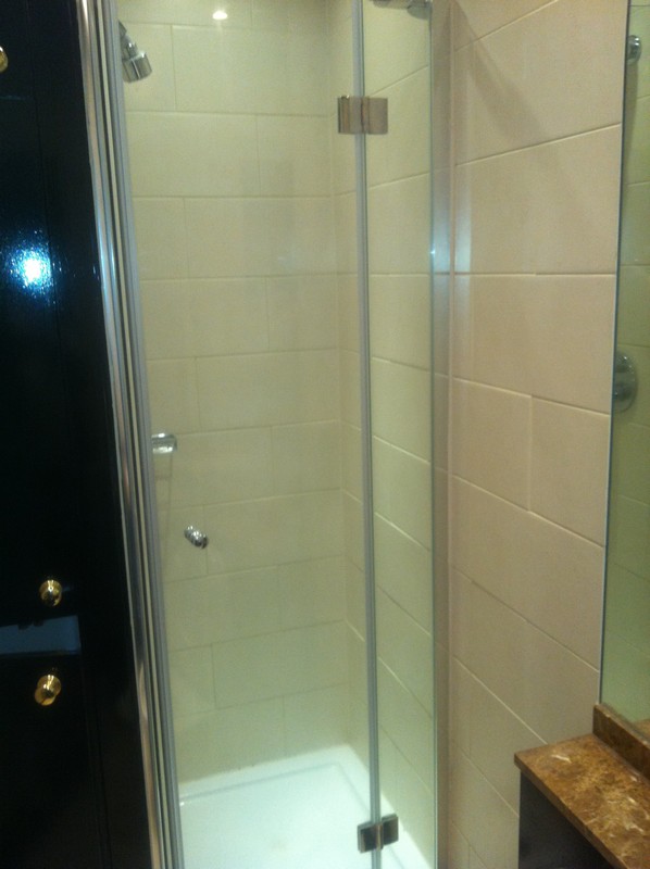 Frameless glass shower enclosure with chrome fittings in Holland Park